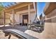 Charming covered patio area perfect for relaxing and entertaining with chairs and an outdoor swing at 2180 Polynesia Cir, Henderson, NV 89074