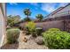 Private backyard featuring desert landscaping, mature trees, and a secure block wall fence at 2485 Jade Sky St, Henderson, NV 89044