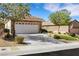 Charming single-story home with a two-car garage, lush landscaping, and inviting curb appeal at 2485 Jade Sky St, Henderson, NV 89044