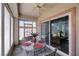 Enclosed patio with ceiling fan, outdoor seating, and sliding door access to the home's interior at 2485 Jade Sky St, Henderson, NV 89044