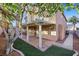 Home's exterior featuring a covered patio, stucco, and lush backyard landscaping at 249 Gentle Springs Dr, Henderson, NV 89012
