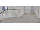 Hallway with white banister and neutral carpets leading to a bathroom at 249 Gentle Springs Dr, Henderson, NV 89012
