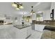 Open kitchen with white cabinets, granite countertops, an island, and views of the living area at 249 Gentle Springs Dr, Henderson, NV 89012