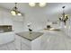 Bright kitchen featuring an island, white cabinets, granite countertops, and seamless flow to living area at 249 Gentle Springs Dr, Henderson, NV 89012