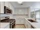 Well-equipped kitchen featuring white cabinets, updated appliances, and sleek countertops at 2633 S Durango Dr # 201, Las Vegas, NV 89117