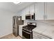 Kitchen area featuring a gas range, modern microwave, and stainless steel refrigerator at 2633 S Durango Dr # 201, Las Vegas, NV 89117