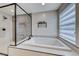 This bathroom highlights the soaking tub, neutral color pallete, and modern window blinds at 2637 Via Monet, Henderson, NV 89044