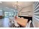 Dining room featuring a long wooden table, modern chandelier, and seamless access to outdoor patio at 2637 Via Monet, Henderson, NV 89044
