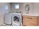 Bright laundry room featuring a modern washer and dryer set next to a stylish vanity with a basin sink and unique flooring at 2637 Via Monet, Henderson, NV 89044