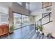 Bright and airy living area with sliding glass doors, staircase, and hardwood floors at 2637 Via Monet, Henderson, NV 89044
