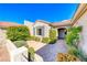 Beautiful home exterior featuring a paved courtyard, neutral tones, complemented by mature landscaping and a tiled roof at 2702 Grand Forks Rd, Henderson, NV 89052