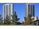 Two high-rise condo buildings with lush trees in foreground under a blue sky at 2877 Paradise Rd # 1804, Las Vegas, NV 89109