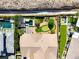 Overhead view of a home with a putting green, patio, desert landscaping, and neighboring houses at 2927 The Peaks Ln, Las Vegas, NV 89138