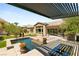 Backyard featuring pool, outdoor seating, fireplace, and lush landscaping at 2927 The Peaks Ln, Las Vegas, NV 89138