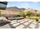 Charming backyard with a putting green, water feature, desert landscaping, and mountain views at 2927 The Peaks Ln, Las Vegas, NV 89138
