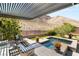 Inviting backyard with a covered patio, water feature, manicured landscaping, and mountain views at 2927 The Peaks Ln, Las Vegas, NV 89138