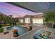 Charming backyard featuring a water feature, putting green, desert landscaping, and covered patio at 2927 The Peaks Ln, Las Vegas, NV 89138