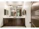 Bathroom featuring double sinks, dark cabinets and a view into the home at 2927 The Peaks Ln, Las Vegas, NV 89138