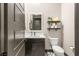Modern half bath featuring a stylish vanity, toilet, and decorative shelves at 2927 The Peaks Ln, Las Vegas, NV 89138