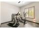 Exercise room with treadmill and elliptical machine, and window with natural light at 2927 The Peaks Ln, Las Vegas, NV 89138