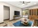 Cozy living room with wood-style flooring, large TV, and a view to the outdoor living space at 2927 The Peaks Ln, Las Vegas, NV 89138