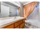 Bathroom featuring a vanity with tile countertop and a bathtub with orange curtains at 3108 Leafwood St, Las Vegas, NV 89108