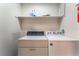 Functional laundry room with stacked washer and dryer, and overhead storage shelf at 3108 Leafwood St, Las Vegas, NV 89108
