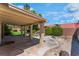 Covered patio area with lush landscaping and a decorative rock feature in the backyard at 3108 Leafwood St, Las Vegas, NV 89108