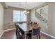 Formal dining room features a large wooden table and chairs, complemented by natural light and staircase view at 3440 Bella Viera Ct, Las Vegas, NV 89141