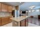 Open kitchen featuring granite countertops, wood cabinets, and an island, connected to the living area at 3440 Bella Viera Ct, Las Vegas, NV 89141
