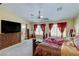 Main bedroom with decorative curtains, ceiling fan, large dresser, and walk-in bathroom at 3440 Bella Viera Ct, Las Vegas, NV 89141
