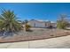 Low angle shot of a single-story house with desert landscaping and a tiled roof at 3912 Branchwood Dr, North Las Vegas, NV 89032