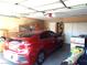 View of the garage with car parked inside, and storage shelves with clutter at 3954 Saddlewood Ct, Las Vegas, NV 89121