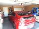 View of the garage with car parked inside, and storage shelves with clutter at 3954 Saddlewood Ct, Las Vegas, NV 89121