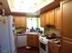 Well-lit kitchen with wood cabinetry, a corner sink, and modern appliances at 3954 Saddlewood Ct, Las Vegas, NV 89121