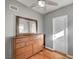 Cozy bedroom featuring wood floors, ceiling fan, and a wooden dresser with a mirror at 4284 Parkdale Ave, Las Vegas, NV 89121