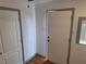 A hallway features hardwood flooring, two doors, a window with blinds, and neutral-colored walls at 4284 Parkdale Ave, Las Vegas, NV 89121