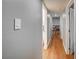 Hallway view featuring hardwood floors, neutral paint, and white door frames, leading to a sitting room with a couch at 4284 Parkdale Ave, Las Vegas, NV 89121