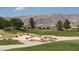 Lush golf course view with sand traps, distant mountains, and well-maintained landscaping at 4410 E Brusca Way, Pahrump, NV 89061