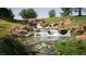 Beautiful multi-tiered waterfall feature flowing into a pond, surrounded by lush greenery at 4410 E Brusca Way, Pahrump, NV 89061