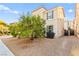 Two-story home with neutral stucco exterior, desert landscaping, dark shutters, and wrought iron side gate at 4533 Lime Straight Dr, Las Vegas, NV 89115