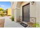 Inviting front entrance with 'hello' doormat, decorative chairs, and an arched stucco entry at 4533 Lime Straight Dr, Las Vegas, NV 89115