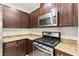 Corner view of kitchen showcasing granite counters, stainless steel oven and dark wood cabinets at 4533 Lime Straight Dr, Las Vegas, NV 89115