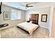 This staged bedroom features neutral colors, a ceiling fan, and lots of natural light from the window at 5019 Quiet Falls Ct, Las Vegas, NV 89141