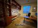 A bright home office features built-in shelving, a desk, and a comfortable workspace at 5019 Quiet Falls Ct, Las Vegas, NV 89141