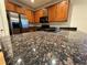 Kitchen featuring stainless steel appliances, granite countertops and wood cabinetry at 5019 Quiet Falls Ct, Las Vegas, NV 89141