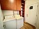 Laundry area with washer and dryer, built-in shelving and cabinets and a door to the exterior at 5019 Quiet Falls Ct, Las Vegas, NV 89141