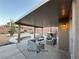A covered patio features modern outdoor furniture and a built-in grill, perfect for entertaining at 5019 Quiet Falls Ct, Las Vegas, NV 89141