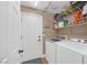 Well-equipped laundry room with modern machines, shelving, and door to outside provide convenience and organization at 5021 Apache Valley Ave, Las Vegas, NV 89131