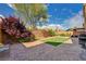 Backyard featuring manicured landscaping, brick-paved patio, putting green, and grill area at 5448 Tulip Hill Ave, Las Vegas, NV 89141
